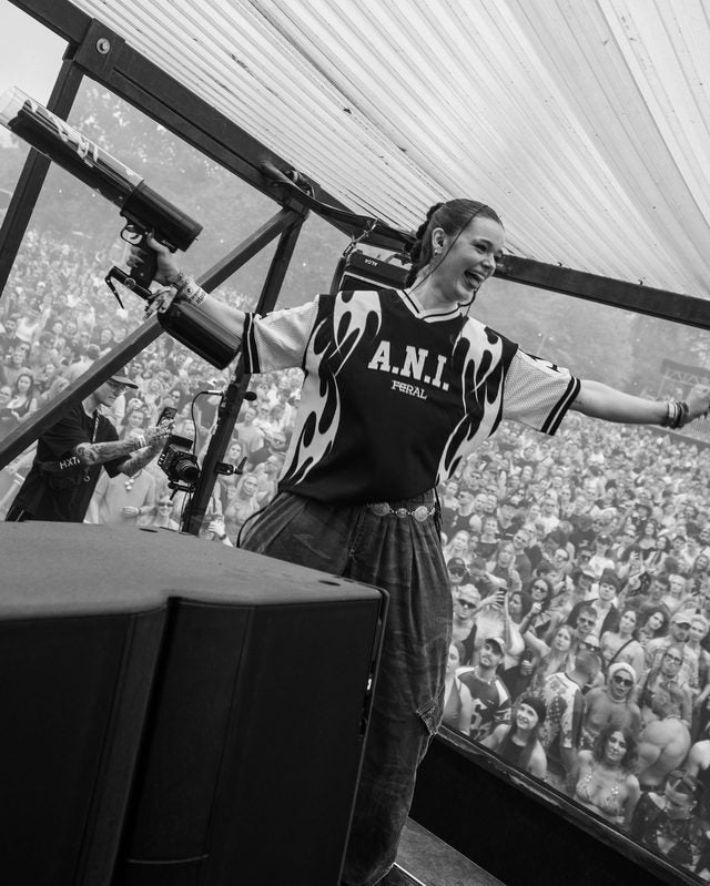 Arms out on stage above the crowd in the monochrome jersey, black and white