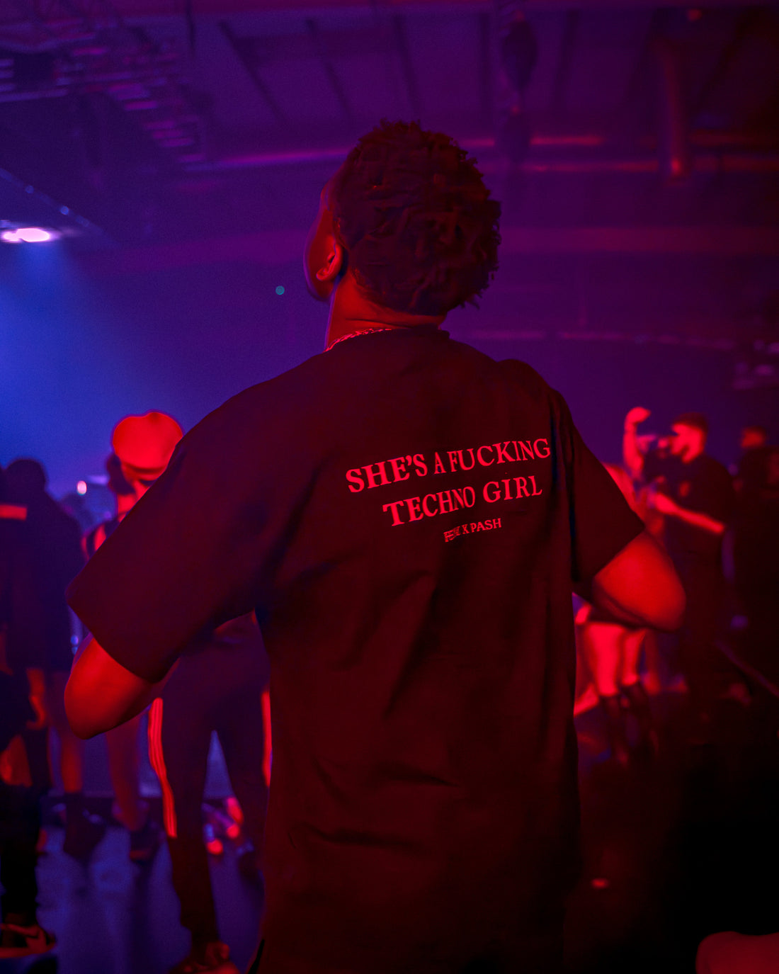 What does feral mean — woman at a hard techno rave embodying feral energy in FERAL clothing