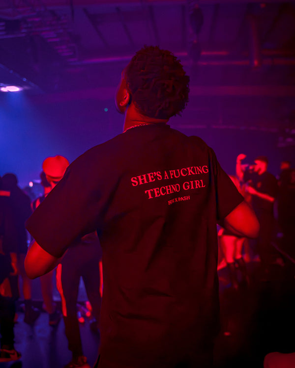 What does feral mean — woman at a hard techno rave embodying feral energy in FERAL clothing