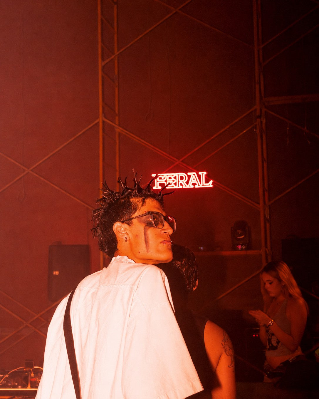 The FERAL neon sign glowing above the rig at a FERAL rave