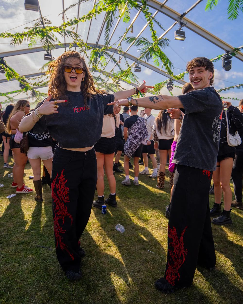 Two friends at a festival, both in the original red SIGILMARKED JEANS