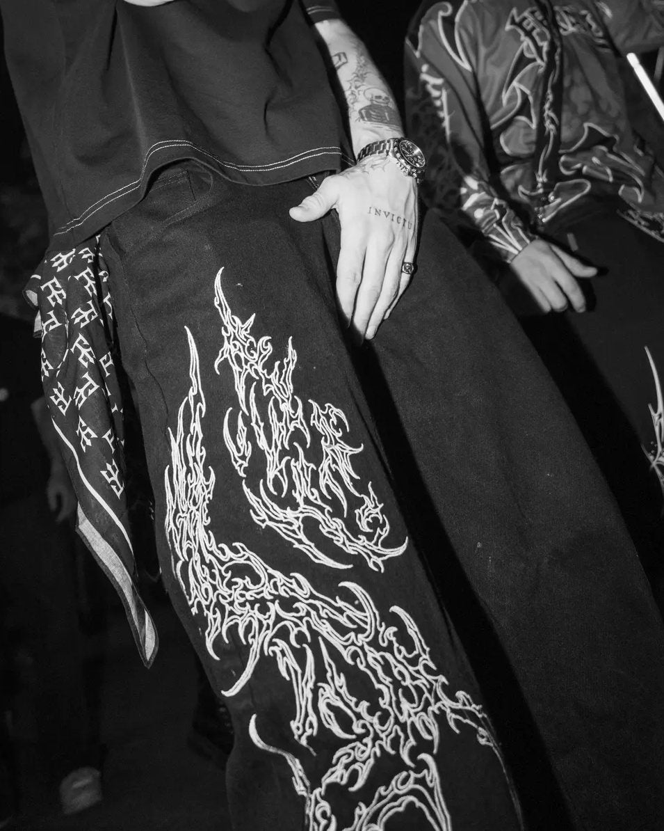 Monochrome SIGILMARKED JEANS in a club, the white embroidery running down the leg