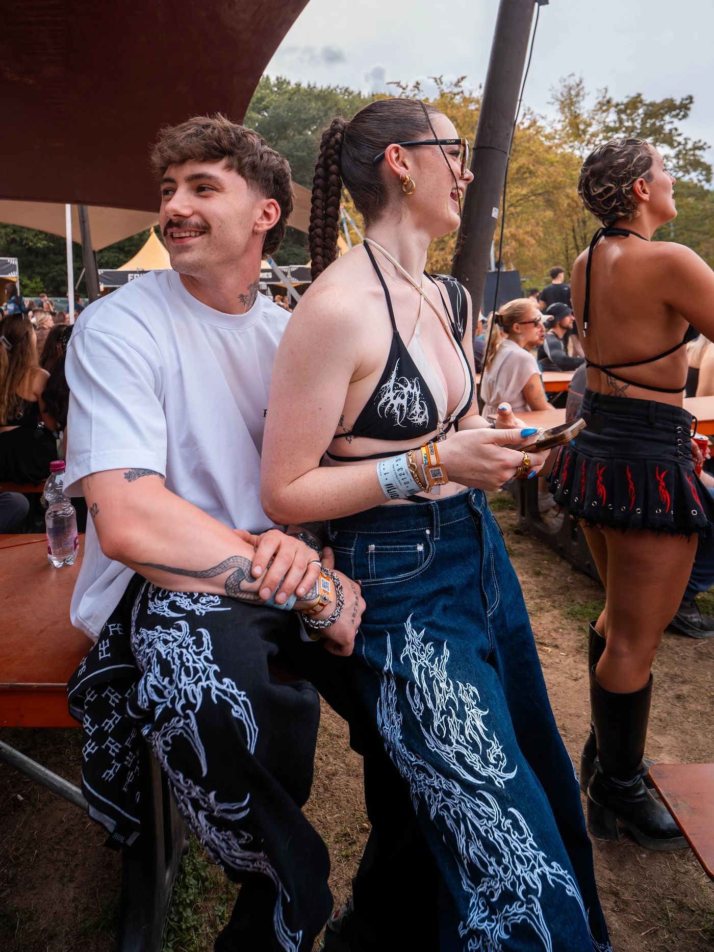 Two people at a festival in SIGILMARKED JEANS, one pair in monochrome and one in denim blue